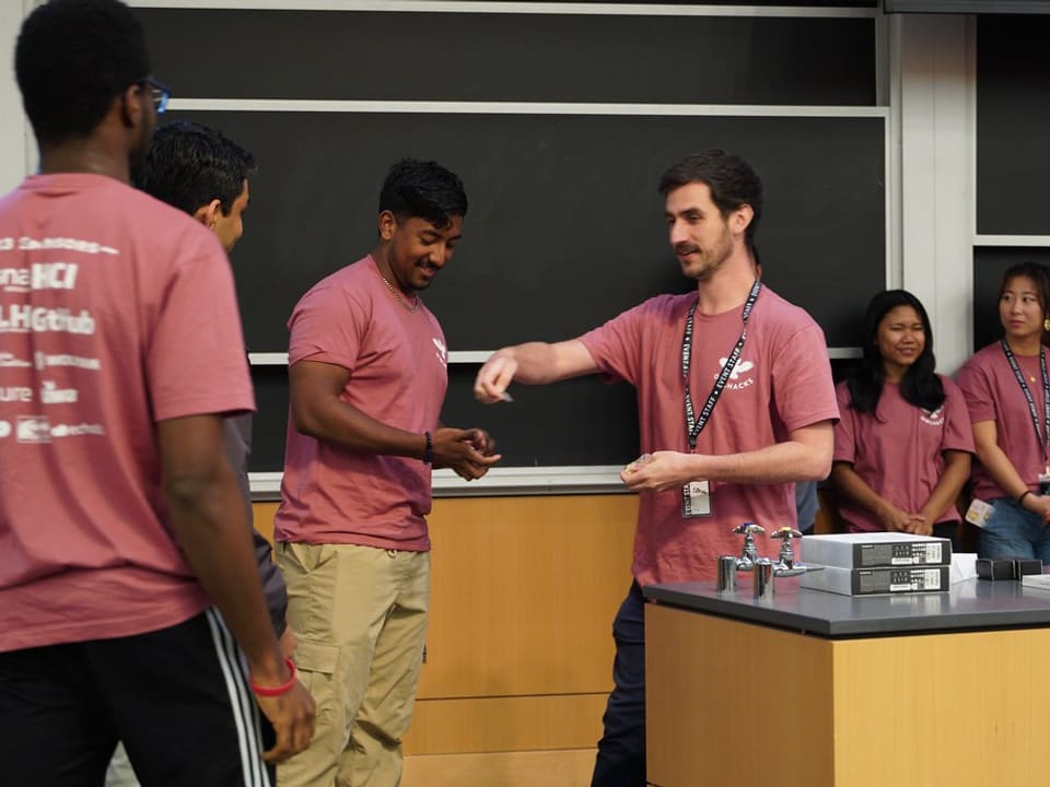 Stephen MacNeil handing out awards to a winning team at OwlHacks